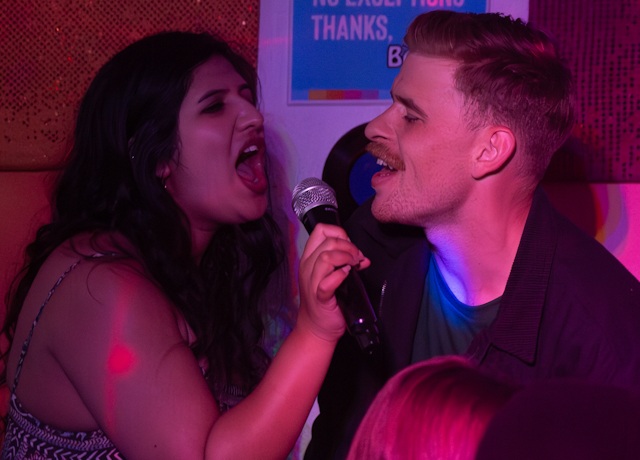 Two singers sharing the mic at Benjys