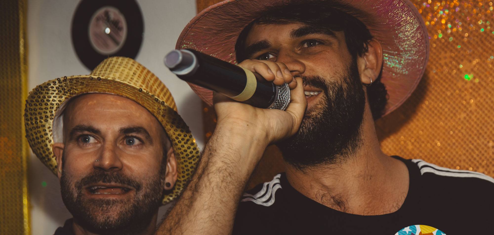 Two friends sharing a karaoke performance at Benjys